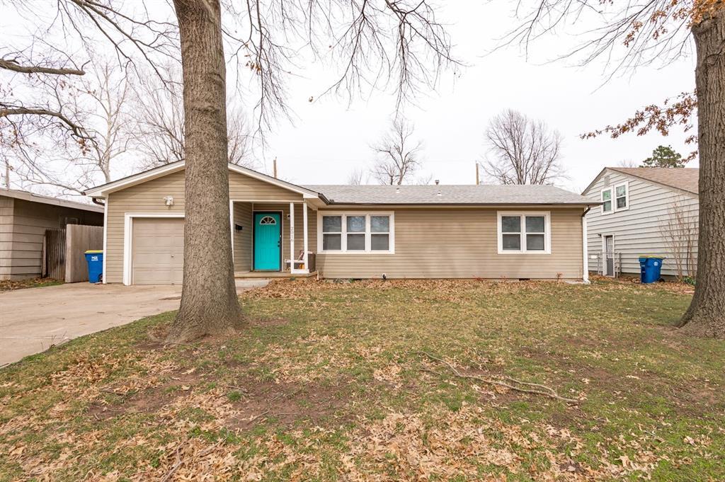 ranch-style home featuring a front lawn, concrete driveway, and an attached garage