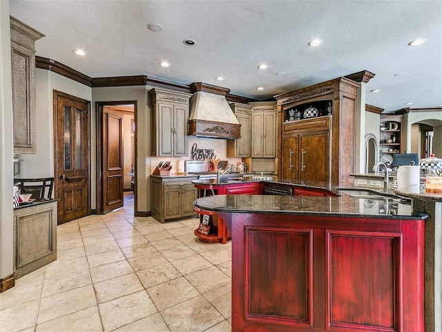 kitchen featuring ornamental molding, premium range hood, a center island with sink, and dark brown cabinets