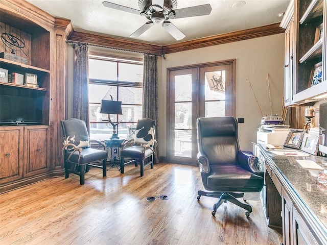 office area featuring light wood-type flooring, ornamental molding, and a ceiling fan