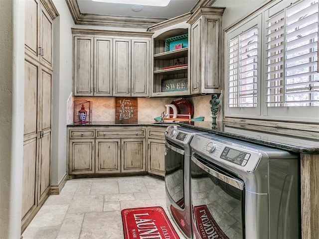 laundry room featuring ornamental molding, cabinet space, stone tile floors, and separate washer and dryer