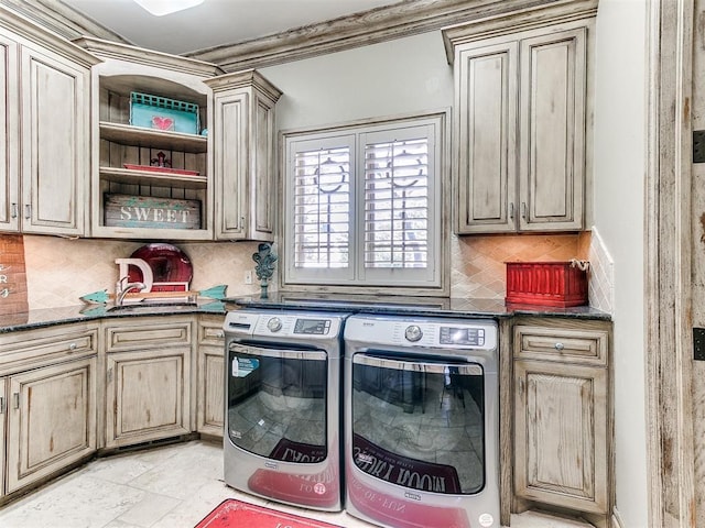 clothes washing area featuring cabinet space, crown molding, washer and clothes dryer, and a sink