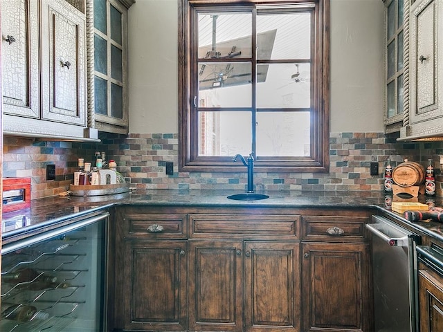 kitchen with a healthy amount of sunlight, beverage cooler, backsplash, and a sink