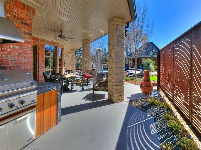 view of patio with exterior kitchen and a ceiling fan