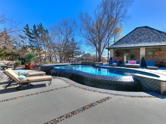 pool with an outbuilding, a jacuzzi, a storage structure, outdoor lounge area, and a patio area