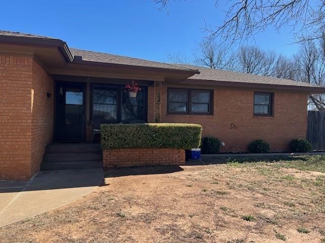 view of front of property featuring brick siding and fence