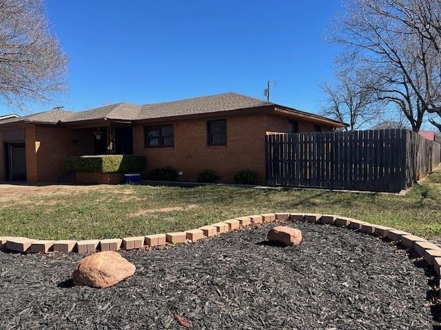 view of side of property featuring a lawn and fence