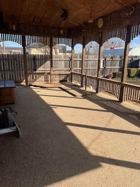 view of patio featuring ceiling fan and fence