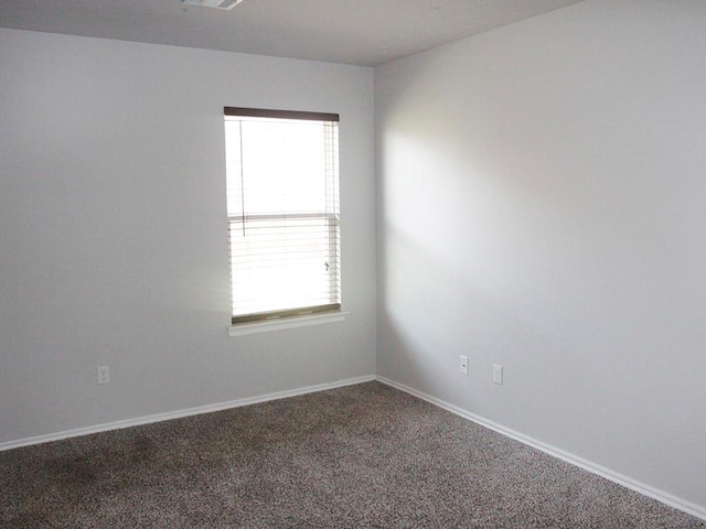 carpeted spare room with plenty of natural light, visible vents, and baseboards