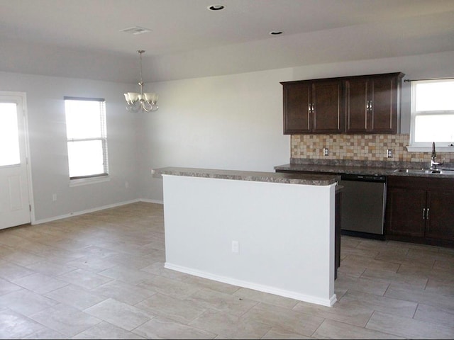 kitchen with a chandelier, a sink, decorative backsplash, dishwasher, and dark countertops