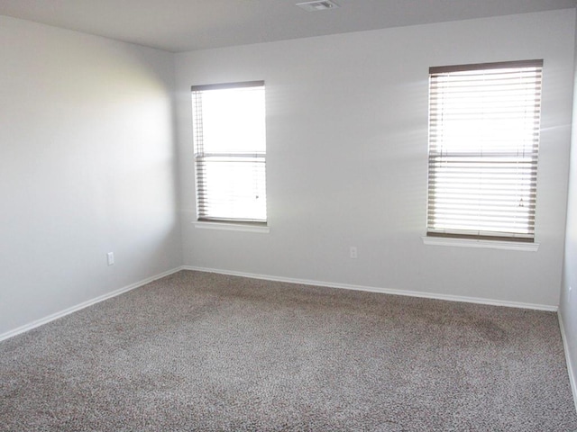 carpeted spare room featuring baseboards