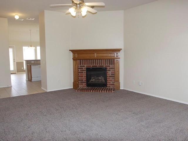 unfurnished living room featuring light tile patterned floors, light colored carpet, a ceiling fan, baseboards, and a brick fireplace