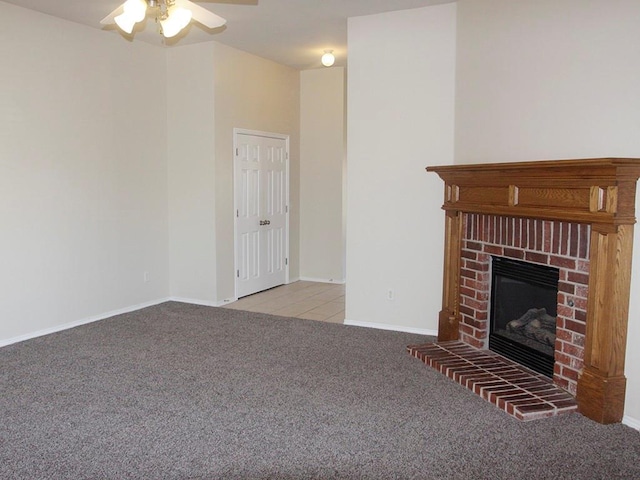 unfurnished living room featuring baseboards, ceiling fan, a fireplace, and light colored carpet