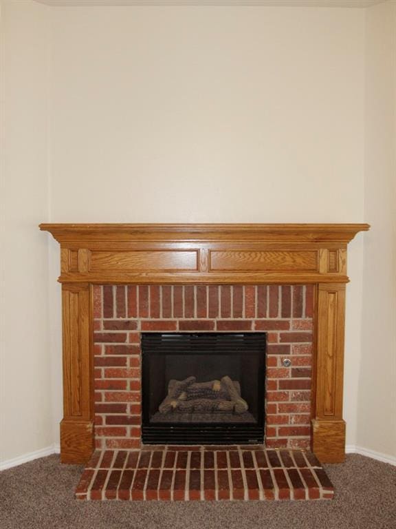 details featuring a fireplace with raised hearth, carpet, and baseboards