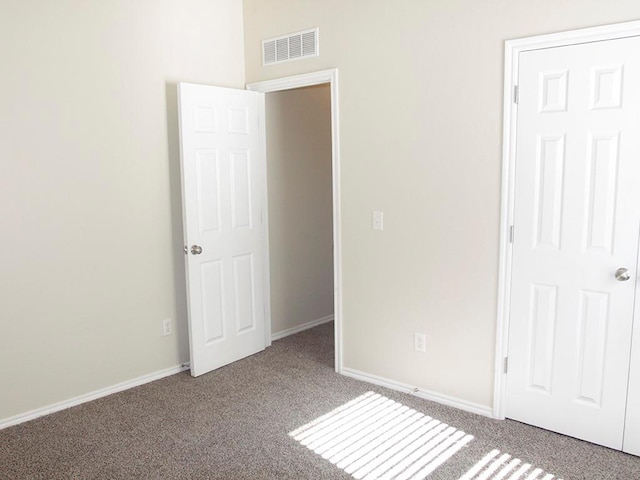 unfurnished bedroom with baseboards, visible vents, and carpet flooring