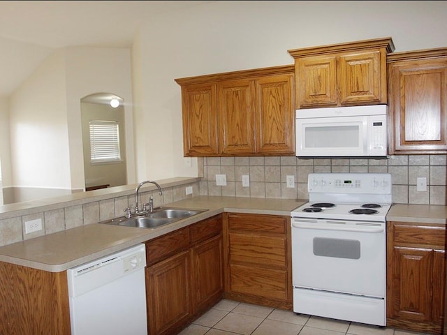 kitchen featuring white appliances, light countertops, and a sink