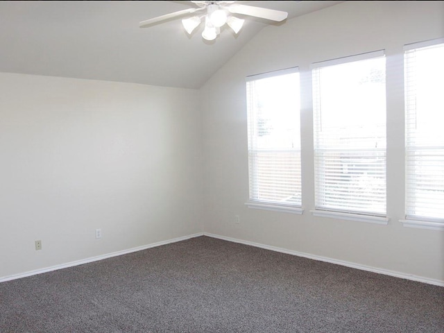 spare room with a ceiling fan, vaulted ceiling, carpet floors, and baseboards