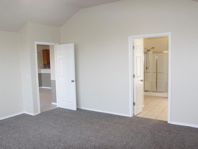 unfurnished bedroom featuring baseboards, vaulted ceiling, and light colored carpet