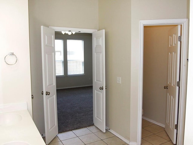 bathroom featuring double vanity, baseboards, toilet, tile patterned flooring, and a sink