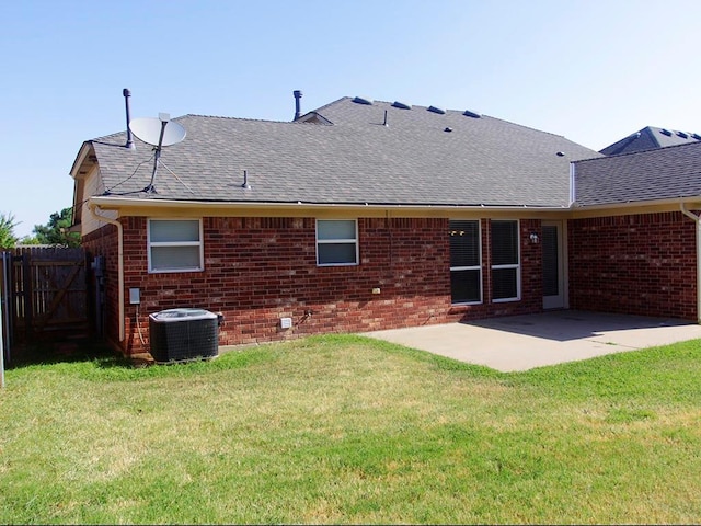 back of house with a yard, a patio, brick siding, and fence