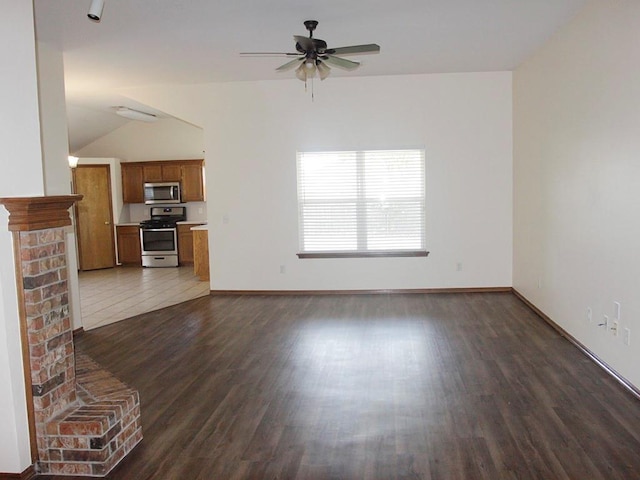 unfurnished living room featuring lofted ceiling, dark wood finished floors, baseboards, and ceiling fan