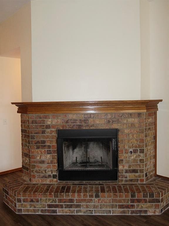 interior details with a fireplace, baseboards, and wood finished floors