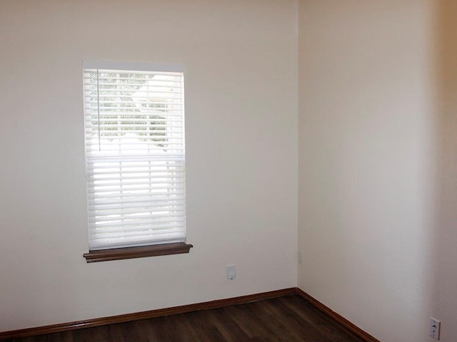 empty room featuring dark wood finished floors and baseboards