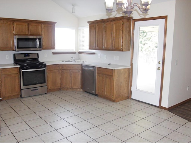 kitchen with stainless steel appliances, brown cabinets, and light countertops