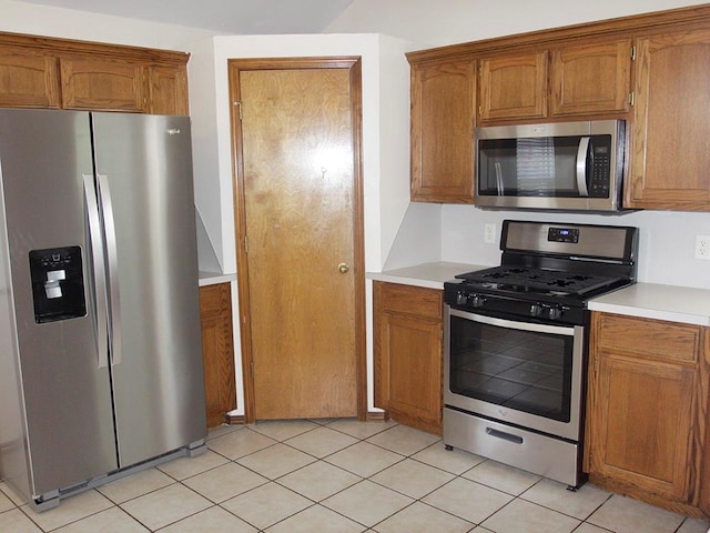 kitchen with light countertops, appliances with stainless steel finishes, and brown cabinetry