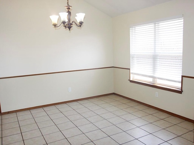 empty room with lofted ceiling, baseboards, and a notable chandelier