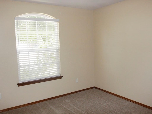 empty room featuring carpet floors and baseboards