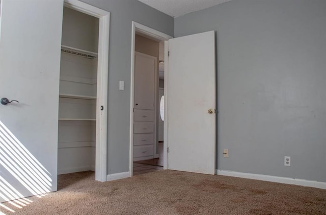 unfurnished bedroom featuring carpet floors, a closet, and baseboards