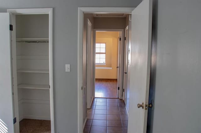 hallway with tile patterned flooring and baseboards