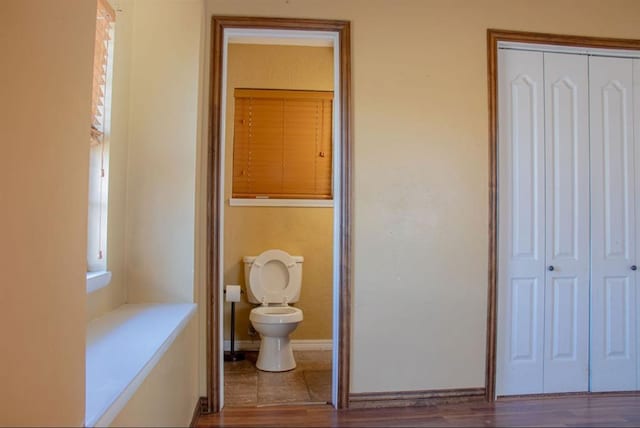 bathroom featuring wood finished floors, toilet, and baseboards