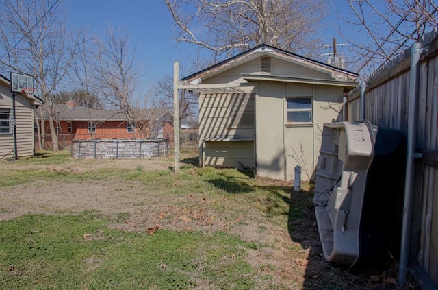 view of property exterior featuring fence, an outdoor pool, and a yard