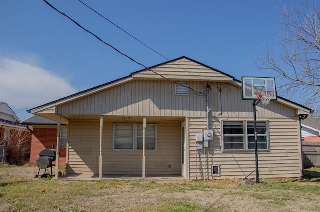 rear view of house featuring a yard and fence