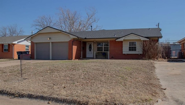 single story home featuring a garage, driveway, brick siding, and a front yard