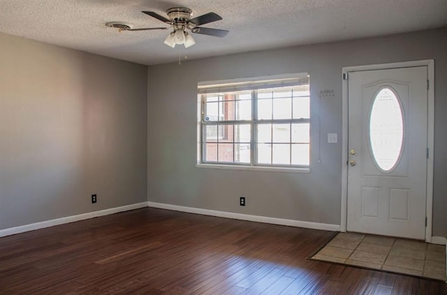 entryway featuring a textured ceiling, wood finished floors, visible vents, and baseboards