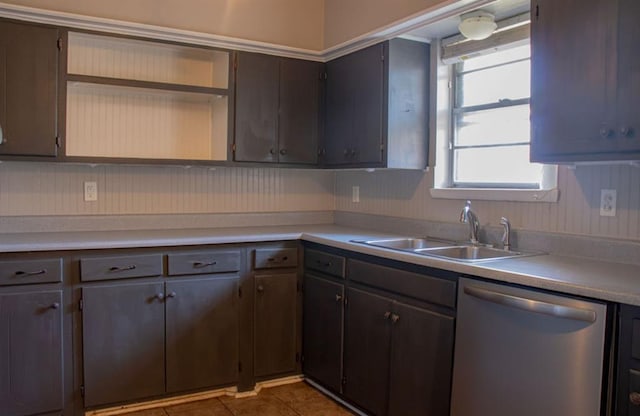 kitchen featuring a sink, light countertops, stainless steel dishwasher, and tile patterned floors