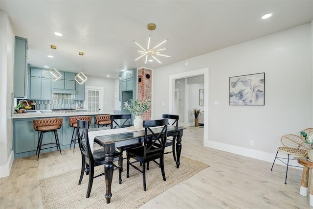 dining space featuring baseboards, recessed lighting, light wood-style flooring, and a notable chandelier