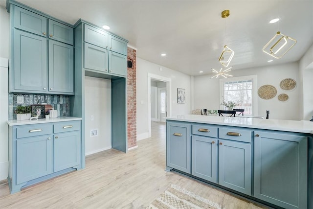 kitchen with recessed lighting, light countertops, hanging light fixtures, light wood-type flooring, and decorative backsplash