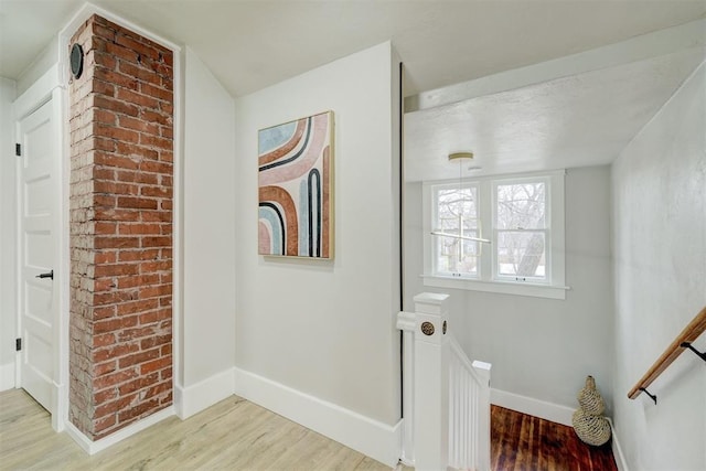 hallway with light wood-type flooring and baseboards