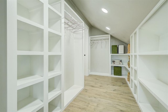 spacious closet featuring lofted ceiling and wood finished floors