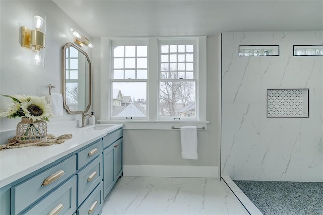 full bathroom featuring a marble finish shower, marble finish floor, vanity, and baseboards