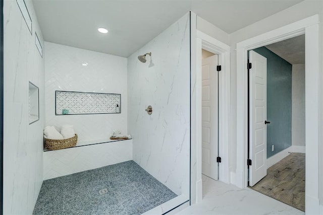 bathroom featuring marble finish floor and walk in shower