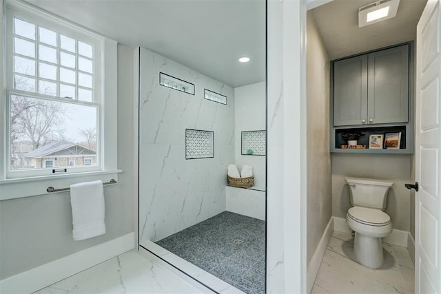 full bathroom featuring toilet, marble finish floor, a marble finish shower, and baseboards