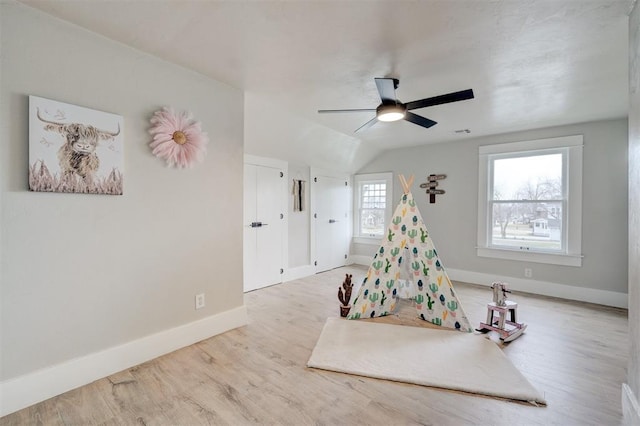 game room featuring visible vents, baseboards, ceiling fan, wood finished floors, and vaulted ceiling