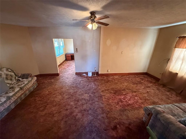 unfurnished living room with carpet floors, ceiling fan, a textured ceiling, and baseboards