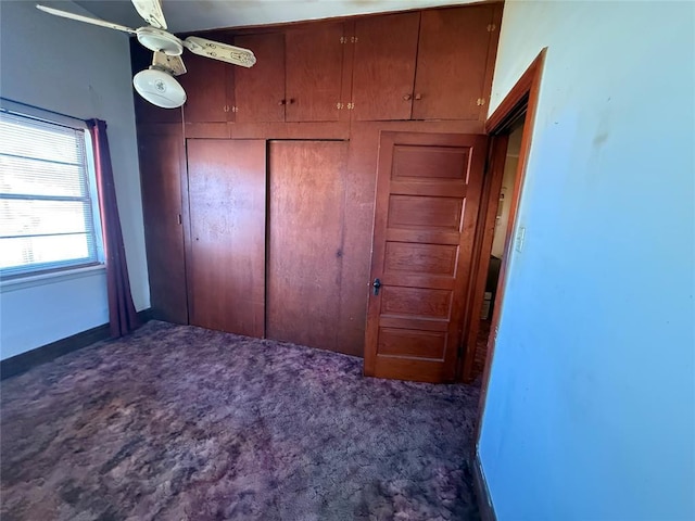 unfurnished bedroom featuring dark carpet and a closet