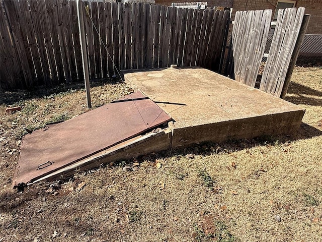 entry to storm shelter featuring fence