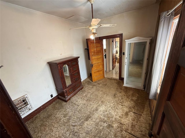 interior space featuring carpet, baseboards, and a ceiling fan